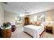 Relaxing bedroom with a queen bed, comfortable armchair, and natural light at 3401 Avenida Madera # B, Bradenton, FL 34210