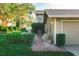 Home exterior with lush green lawn, low landscaping, a brick path, and driveway with grass at 3401 Avenida Madera # B, Bradenton, FL 34210