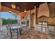 Outdoor kitchen and dining area with fireplace and built-in grill at 3703 Douglas Pl, Palm Harbor, FL 34683