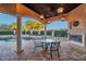 Outdoor kitchen with fireplace, dining area, and built-in grill at 3703 Douglas Pl, Palm Harbor, FL 34683