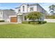 Two-story house with white siding, brown garage door, and lush green lawn at 4101 W Mullen Ave, Tampa, FL 33609