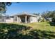 Landscaped backyard with green grass and a view of the home's exterior at 5733 Heronpark Pl, Lithia, FL 33547