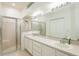 Bathroom with double sink vanity, large mirror, and glass-enclosed shower at 5733 Heronpark Pl, Lithia, FL 33547
