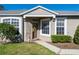 Front entry of charming house featuring a covered porch and lush landscaping at 5733 Heronpark Pl, Lithia, FL 33547