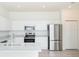 Bright kitchen featuring white cabinets, marble countertops, and stainless steel appliances at 5733 Heronpark Pl, Lithia, FL 33547