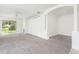 Open-concept living area featuring neutral carpet, archways, and abundant natural light at 5733 Heronpark Pl, Lithia, FL 33547