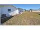 Backyard view showing a grassy area, AC unit, and home exterior at 703 Rutgers Pl, Sun City Center, FL 33573