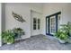 Front entry with dark blue door, white trim, and potted plants at 712 Manns Harbor Dr, Apollo Beach, FL 33572