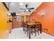 Dining area with a wooden table, six chairs, and an orange accent wall at 7505 Eastmoor Ct, Tampa, FL 33615