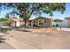 Single-story house with a green facade, covered carport, and mature tree in front at 7505 Eastmoor Ct, Tampa, FL 33615