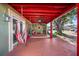 Covered patio features a red wooden structure, hanging chair, and comfortable seating at 7505 Eastmoor Ct, Tampa, FL 33615