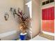 Red front door with welcome mat and potted plants at 7905 Charing Cross Way, Palmetto, FL 34221