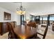 Elegant dining room with a large wood table and chandelier, overlooking living room at 9415 Blind Pass Rd # 601, St Pete Beach, FL 33706
