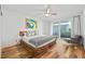 Main bedroom with wooden platform bed, hardwood floors, and access to a balcony at 1012 N Shore Ne Dr # 14, St Petersburg, FL 33701