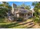 Back exterior view showing deck and stone chimney at 102 Old Mill Pond Rd, Palm Harbor, FL 34683