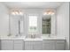 Double vanity bathroom with a large mirror and window at 10507 Daybreak Gln, Parrish, FL 34219