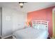 Bedroom with coral accent wall and a queen-size bed at 10507 Daybreak Gln, Parrish, FL 34219