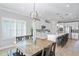 Open concept dining area with modern light fixture and wooden table at 10507 Daybreak Gln, Parrish, FL 34219