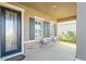 Covered front porch with seating area and stone accents at 10507 Daybreak Gln, Parrish, FL 34219