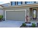Two-car garage with neutral-colored doors and landscaping at 10507 Daybreak Gln, Parrish, FL 34219
