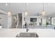 Modern kitchen with island, stainless steel sink, and view into living room at 10507 Daybreak Gln, Parrish, FL 34219