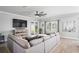 Living room with large sectional sofa, TV, and sliding doors to backyard at 10507 Daybreak Gln, Parrish, FL 34219