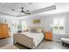 Main bedroom with king-size bed, wood floors, and a tray ceiling at 10507 Daybreak Gln, Parrish, FL 34219