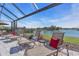 Screened patio with lounge chairs and tranquil lake view at 10612 Giddens Pl, Palmetto, FL 34221