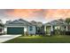 Two-story house with green garage door, stone accents, and landscaped lawn at 142 Fairway Rd, Rotonda West, FL 33947