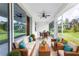 Relaxing screened porch with wicker furniture and ceiling fan at 142 Fairway Rd, Rotonda West, FL 33947