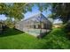 Screened-in pool with surrounding grassy area at 15909 Amberly Dr, Tampa, FL 33647