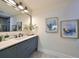 Modern bathroom with blue vanity, frameless shower, and art at 1846 3Rd S St, St Petersburg, FL 33705