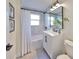 White bathroom with bathtub, vanity, and gray tile at 1846 3Rd S St, St Petersburg, FL 33705
