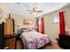 Bright bedroom with floral bedding, ceiling fan, and red curtains at 2729 Garden Falls Dr, Brandon, FL 33511