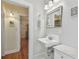 Small bathroom with pedestal sink, marble countertop, and view into dining area at 2925 W Tambay Ave, Tampa, FL 33611