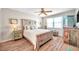 Spacious bedroom with rustic wood bed frame and ceiling fan at 460 Paula S Dr # 101, Dunedin, FL 34698