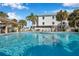 Community pool with lounge chairs and covered seating area at 460 Paula S Dr # 101, Dunedin, FL 34698