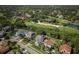 Aerial view of the property outlined in blue, showcasing the backyard, mature trees and golf course views at 5951 Bay Dr, Gulfport, FL 33707