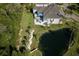 Aerial view of the backyard pond, covered patio, and lush landscaping of this home at 5951 Bay Dr, Gulfport, FL 33707