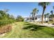 Expansive backyard with lush lawn, mature trees, and partial view of a modern white home at 5951 Bay Dr, Gulfport, FL 33707