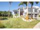 Two-story house with gray shutters, palm trees, and a pond at 5951 Bay Dr, Gulfport, FL 33707