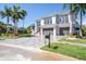 Two-story home with modern design, gray paver driveway, and palm trees at 5951 Bay Dr, Gulfport, FL 33707