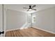 A cozy bedroom featuring wood-look flooring, ceiling fan and bright natural light at 7801 17Th N Way, St Petersburg, FL 33702