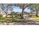 Tan house with mature landscaping, large trees, and a long driveway at 7801 17Th N Way, St Petersburg, FL 33702