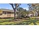Tan house with mature landscaping, large trees, and a two-car garage at 7801 17Th N Way, St Petersburg, FL 33702