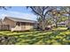 Tan house with mature landscaping, large trees, and a two-car garage at 7801 17Th N Way, St Petersburg, FL 33702