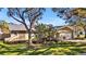 Tan house with mature landscaping, large trees, and a two-car garage at 7801 17Th N Way, St Petersburg, FL 33702