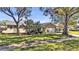 Tan house with mature landscaping, large trees, and a two-car garage at 7801 17Th N Way, St Petersburg, FL 33702