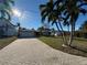 Tan house with a large paved driveway, and two palm trees in the front yard at 10128 Yacht Club Dr, Treasure Island, FL 33706