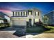 Two-story house with a brick driveway, lit at night at 1192 Multiflora Loop, Lutz, FL 33558
